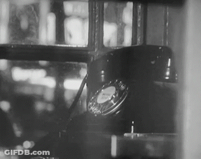 A Black And White Photo Of A Telephone Sitting In A Window GIF
