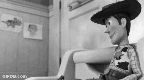 A Black And White Photo Of A Toy Story Woody Sitting In A Chair . GIF