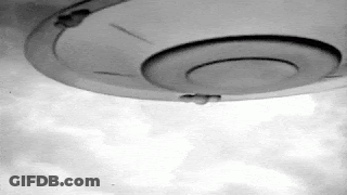 A Black And White Photo Of A Ufo Flying Through The Sky . GIF