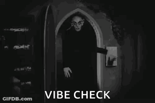 A Black And White Photo Of A Vampire In A Doorway . GIF