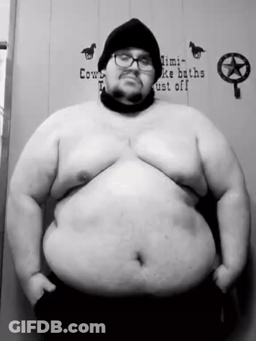 A Black And White Photo Of A Very Fat Man With Glasses And A Beanie . GIF