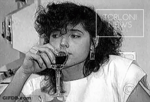 A Black And White Photo Of A Woman Drinking A Glass Of Wine With The Words Torloni News Above Her GIF
