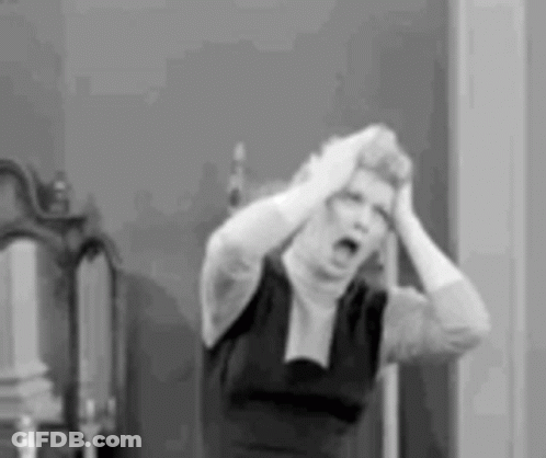 A Black And White Photo Of A Woman Holding Her Head In A Room . GIF