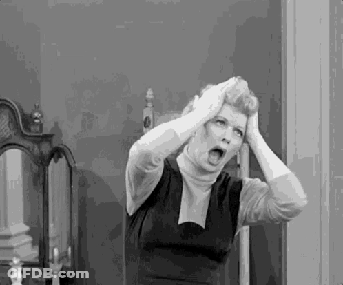 A Black And White Photo Of A Woman Holding Her Head In A Room . GIF