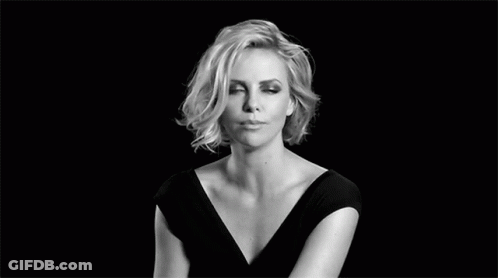 A Black And White Photo Of A Woman In A Black Dress Making A Face . GIF