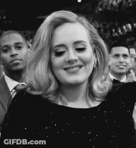 A Black And White Photo Of A Woman In A Black Dress Smiling . GIF