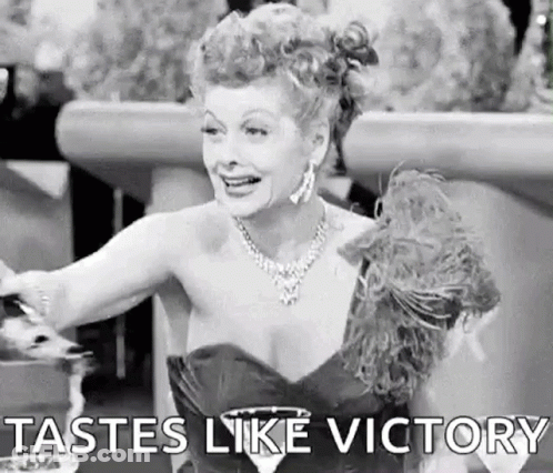 A Black And White Photo Of A Woman In A Dress Holding A Glass Of Wine And Saying `` Tastes Like Victory '' . GIF