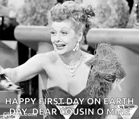 A Black And White Photo Of A Woman In A Dress Sitting At A Table With A Martini In Her Hand . GIF