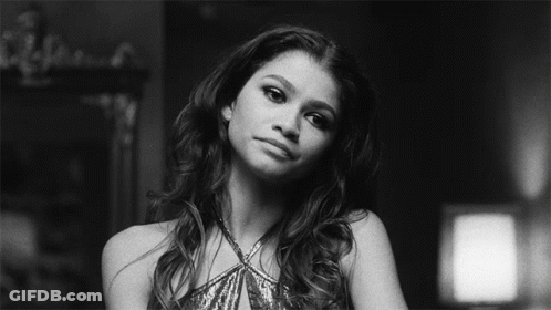 A Black And White Photo Of A Woman In A Sequined Dress Looking At The Camera . GIF