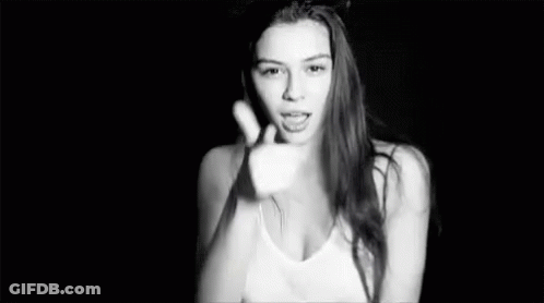 A Black And White Photo Of A Woman In A Tank Top Making A Funny Face . GIF