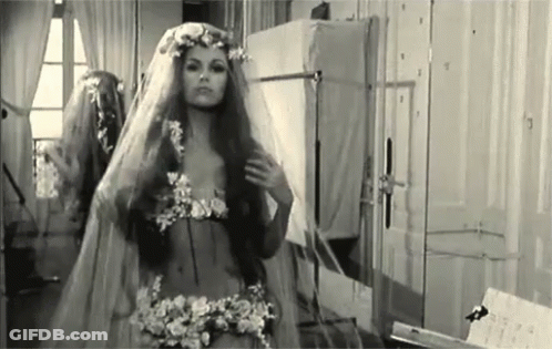 A Black And White Photo Of A Woman In A Wedding Dress And Veil . GIF