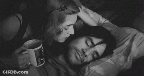 A Black And White Photo Of A Woman Kissing A Man On The Cheek . GIF