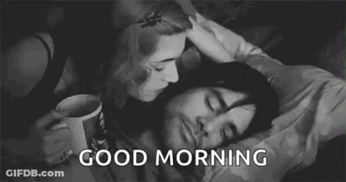 A Black And White Photo Of A Woman Kissing A Man On The Cheek . GIF