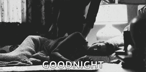 A Black And White Photo Of A Woman Laying On A Bed With The Words `` Goodnight '' Above Her . GIF
