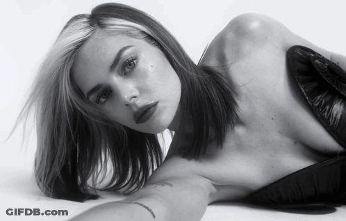 A Black And White Photo Of A Woman Laying On Her Stomach GIF