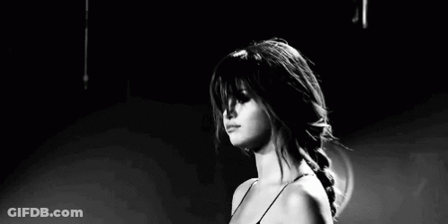 A Black And White Photo Of A Woman Making A Funny Face While Standing On A Stage . GIF