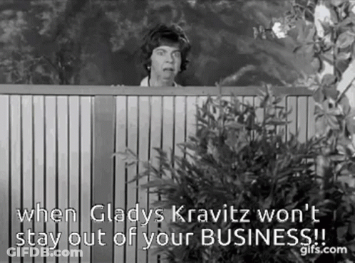 A Black And White Photo Of A Woman Peeking Over A Wooden Fence With A Quote . GIF