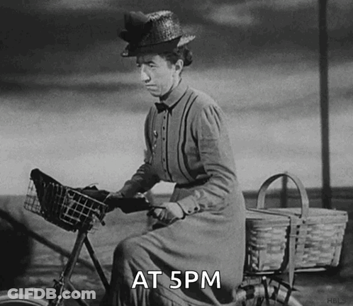 A Black And White Photo Of A Woman Riding A Bike With The Words At 5Pm Written Below Her GIF