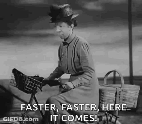A Black And White Photo Of A Woman Riding A Bike With The Words `` Faster , Faster , Here It Comes '' GIF