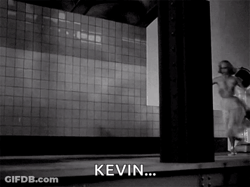 A Black And White Photo Of A Woman Running In A Room With The Word Kevin In The Corner GIF