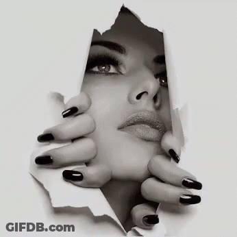 A Black And White Photo Of A Woman 'S Face Behind A Piece Of Paper . GIF