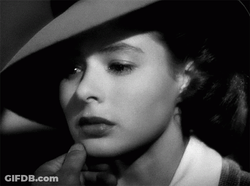 A Black And White Photo Of A Woman 'S Face With A Hat On GIF
