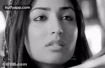 A Black And White Photo Of A Woman 'S Face With A Serious Look On Her Face . GIF
