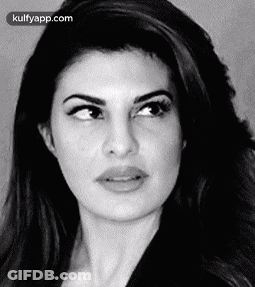 A Black And White Photo Of A Woman 'S Face With A Serious Look On Her Face . GIF