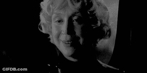 A Black And White Photo Of A Woman 'S Face With A Serious Look On Her Face . GIF