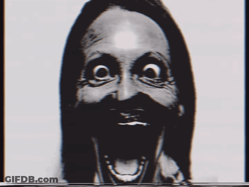 A Black And White Photo Of A Woman 'S Face With A Surprised Expression GIF