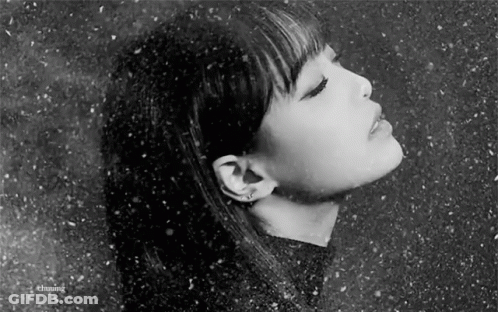 A Black And White Photo Of A Woman 'S Face With Her Eyes Closed In The Snow . GIF