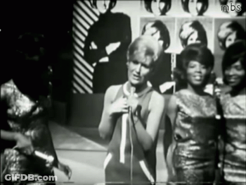 A Black And White Photo Of A Woman Singing Into A Microphone With Mbs Written On The Bottom GIF