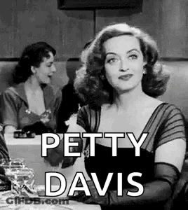 A Black And White Photo Of A Woman Sitting At A Table With The Words `` Petty Davis '' . GIF