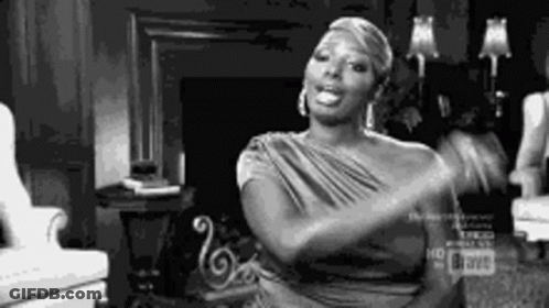 A Black And White Photo Of A Woman Sitting In A Chair . GIF