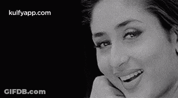 A Black And White Photo Of A Woman Smiling And Looking At The Camera . GIF
