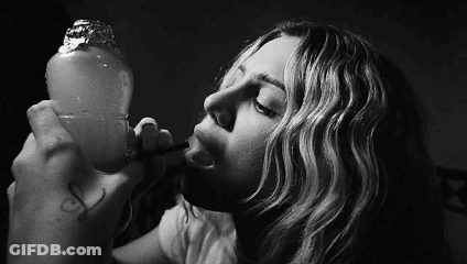 A Black And White Photo Of A Woman Smoking A Hookah GIF