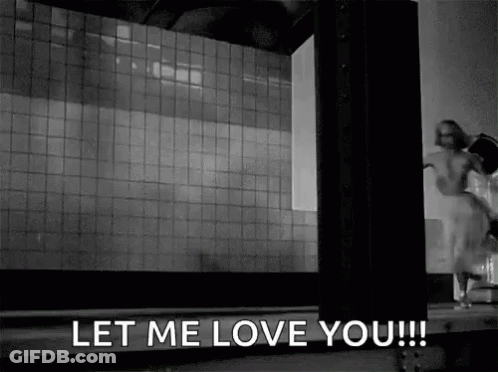 A Black And White Photo Of A Woman Standing In Front Of A Building . GIF