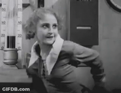 A Black And White Photo Of A Woman Standing In Front Of A Thermometer And Smiling . GIF