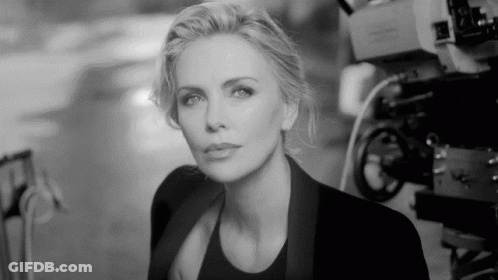 A Black And White Photo Of A Woman Standing In Front Of Cameras GIF