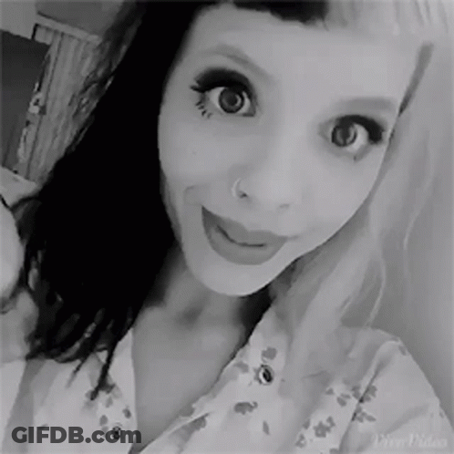A Black And White Photo Of A Woman Taking A Selfie With Her Nose Ring . GIF
