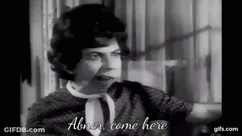 A Black And White Photo Of A Woman Talking To Another Woman In A Room . GIF
