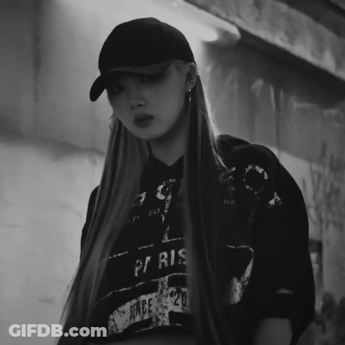A Black And White Photo Of A Woman Wearing A Hat And A Paris Shirt GIF