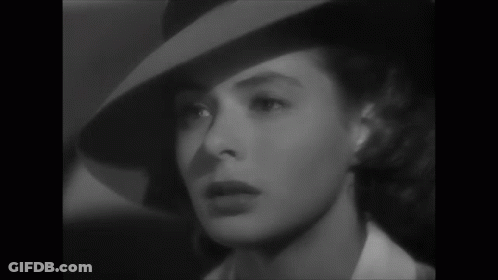 A Black And White Photo Of A Woman Wearing A Hat And A White Shirt GIF