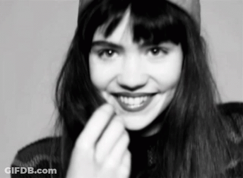 A Black And White Photo Of A Woman Wearing A Hat And Smiling . GIF