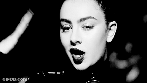 A Black And White Photo Of A Woman Wearing A Leather Jacket And Lipstick . GIF