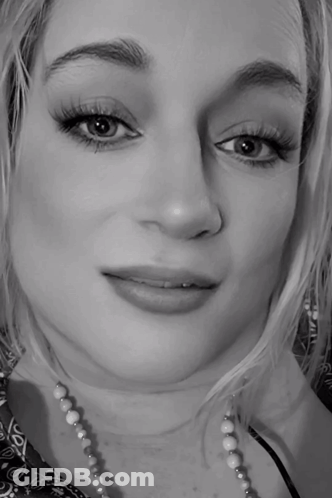 A Black And White Photo Of A Woman Wearing A Necklace GIF