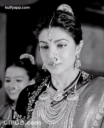 A Black And White Photo Of A Woman Wearing A Nose Ring And A Necklace . GIF