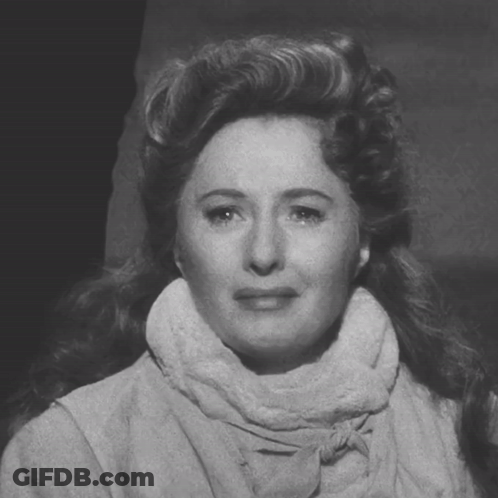 A Black And White Photo Of A Woman Wearing A Scarf Around Her Neck GIF