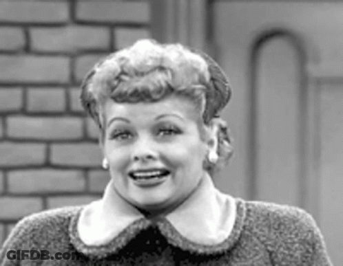 A Black And White Photo Of A Woman Wearing A Sweater And Earrings . GIF