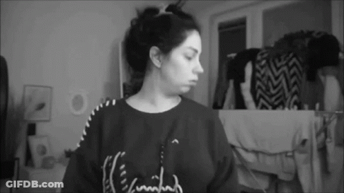 A Black And White Photo Of A Woman Wearing A Sweater That Says ' I 'M Tired ' On It . GIF